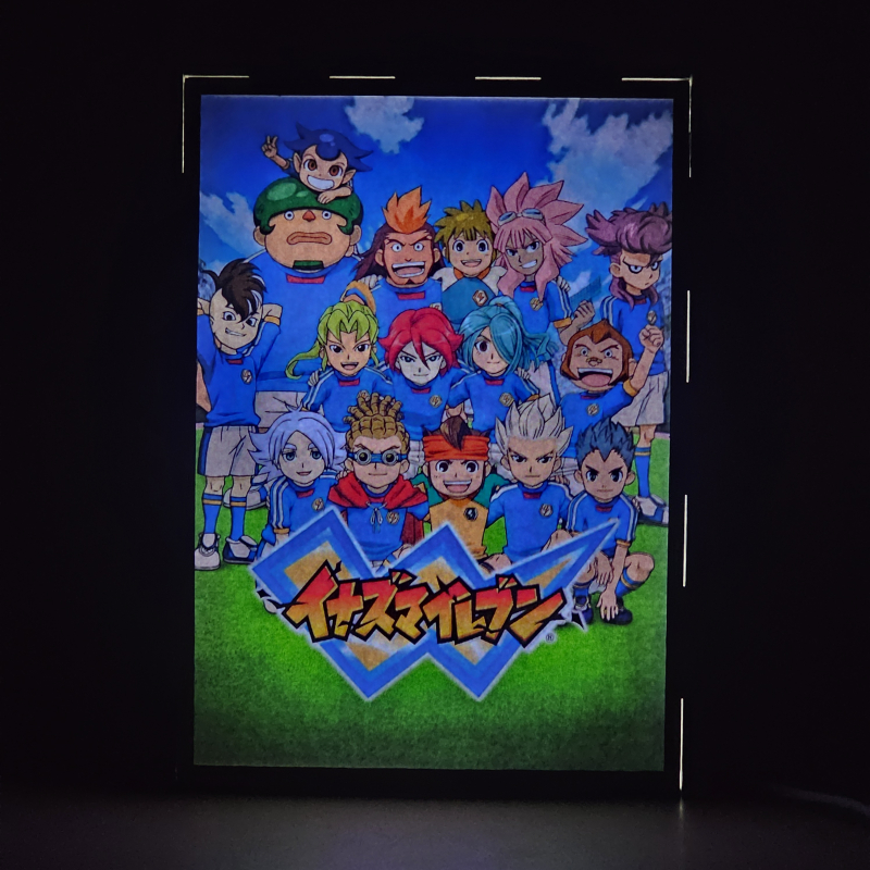 Lámpara ánime/manga  Inazuma Eleven  con doble imagen del grupo Mark Evans, Axel Blaze, Jude Sharp, Nathan Swift, Shawn Frost, Austin Hobbes, Caleb Stonewall, Xavier Foster, Claude Beacons, Bryce Withingale, Archer Hawkins, Thor Stoutberg, Kabeyama Heigorou y Darren LaChance, vista encendida, donde se revela la ilustración completa al encender la luz LED.