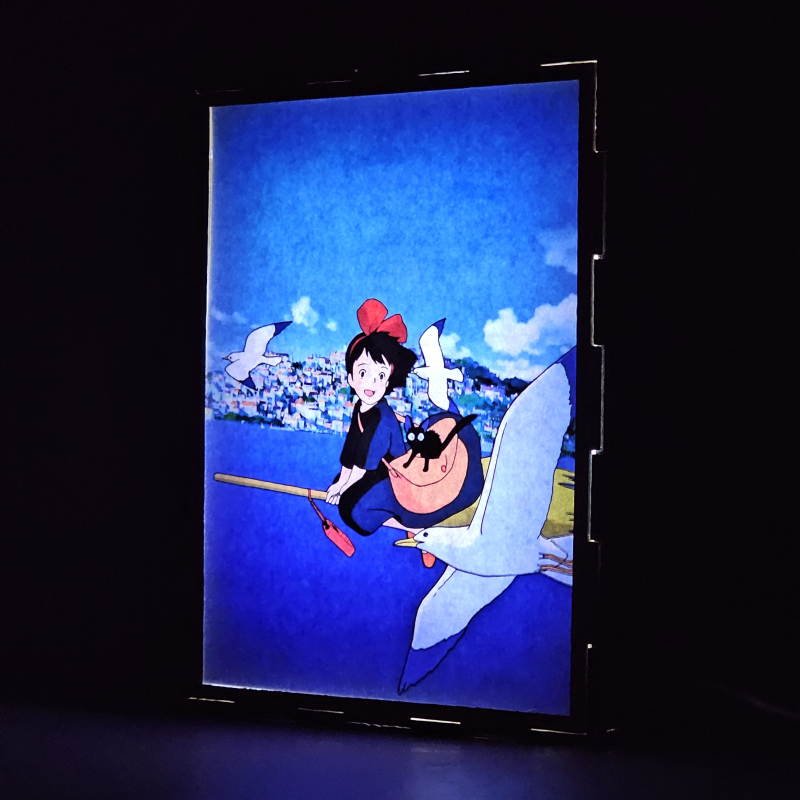 Lámpara ánime  Kiki: Entregas a domicilio  con doble imagen de la pareja Kiki y Jiji, vista encendida, donde se revela la ilustración completa al encender la luz LED.