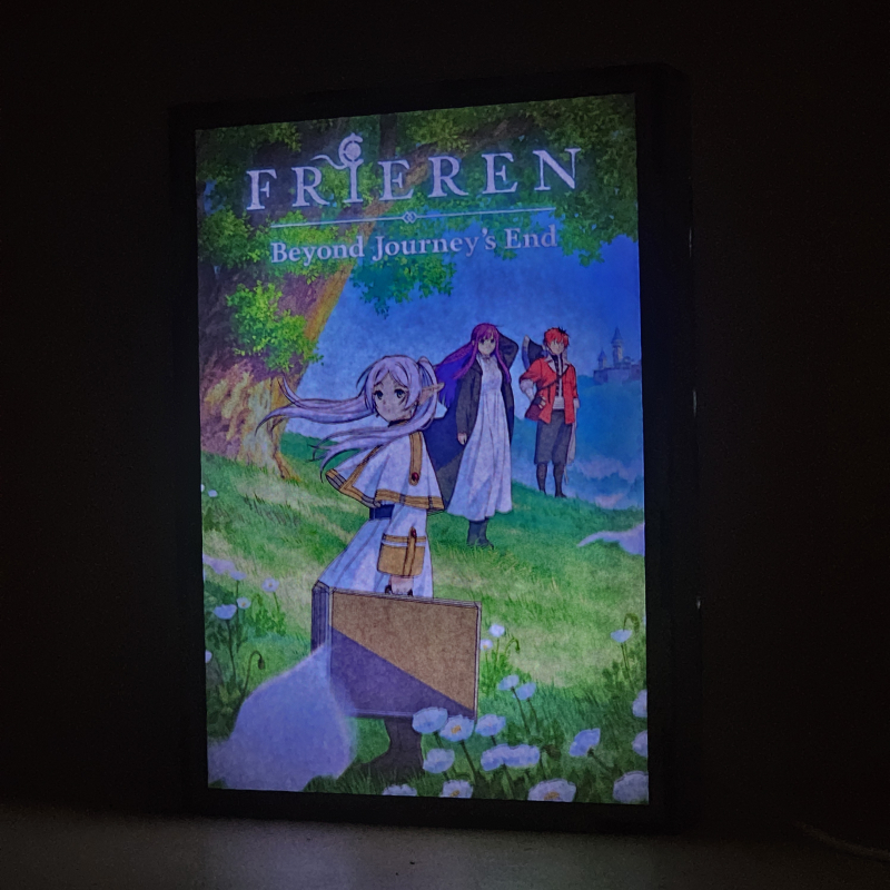 Lámpara ánime/manga  Frieren  con doble imagen del grupo Frieren, Fern y Stark, vista encendida, donde se revela la ilustración completa al encender la luz LED.
