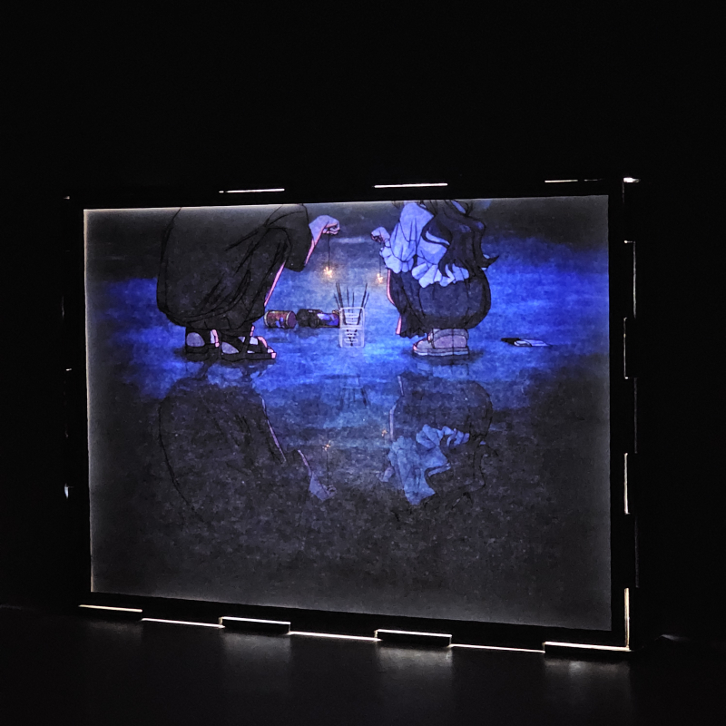 Lámpara ánime/manga  Kaoru Hana wa Rin to Saku  con doble imagen de la pareja Kaoruko Waguri y Rintaro Tsumugi, vista encendida, donde se revela la ilustración completa al encender la luz LED.